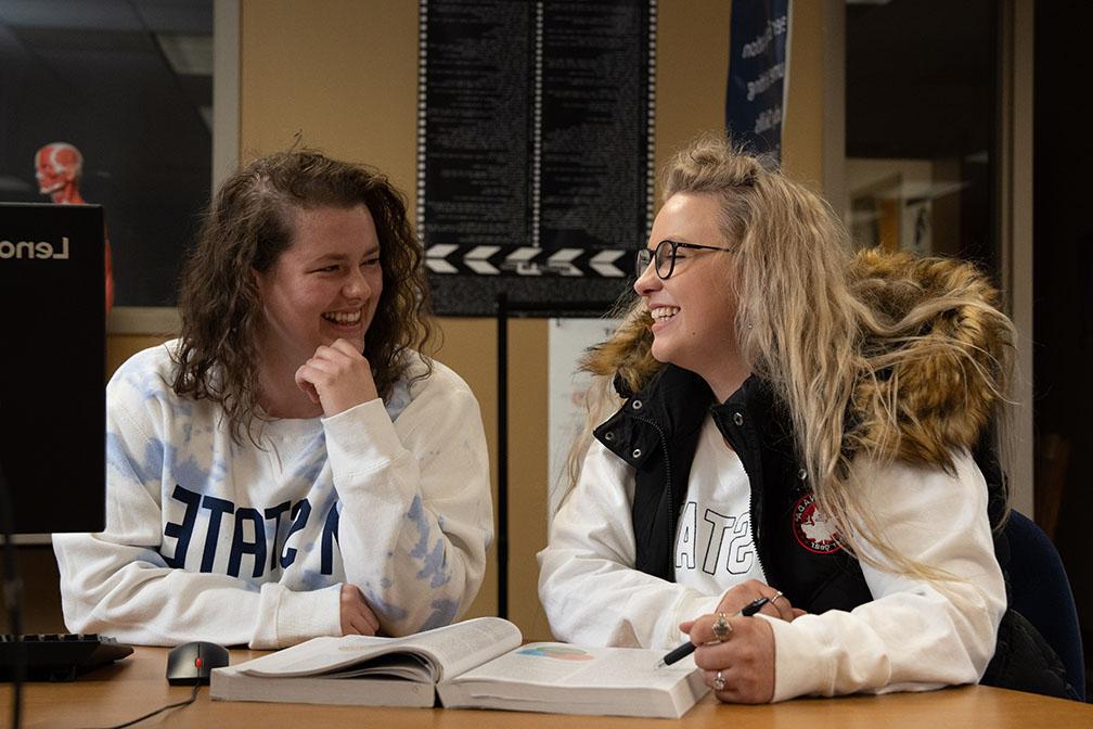 Two seated students laughing