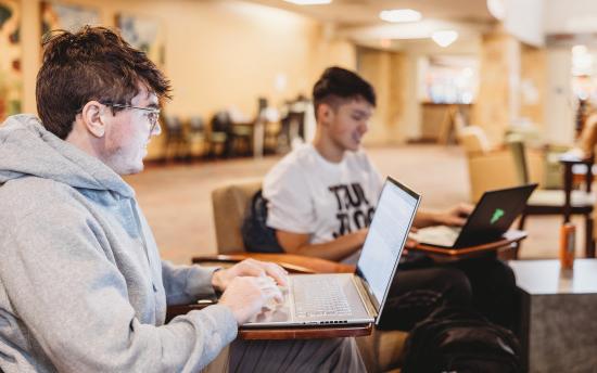 Photo of two students studying in the commons